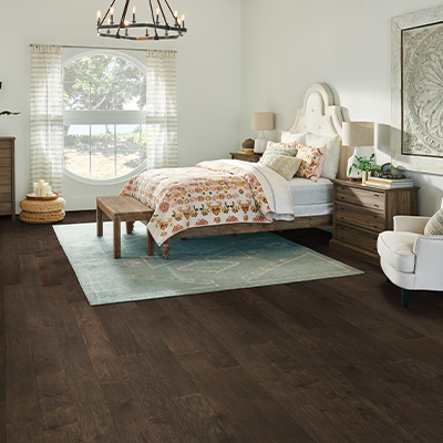 green area rug in bedroom with hardwood floors