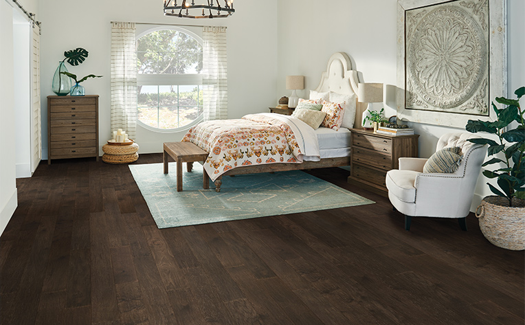 white area rug in bedroom with hardwood floors